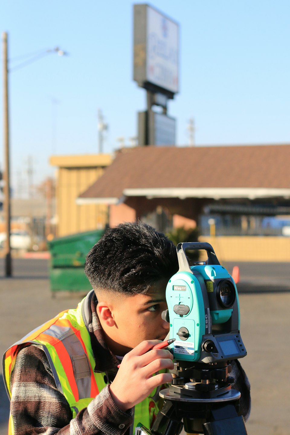 Surveyor uses a total station on a construction site.